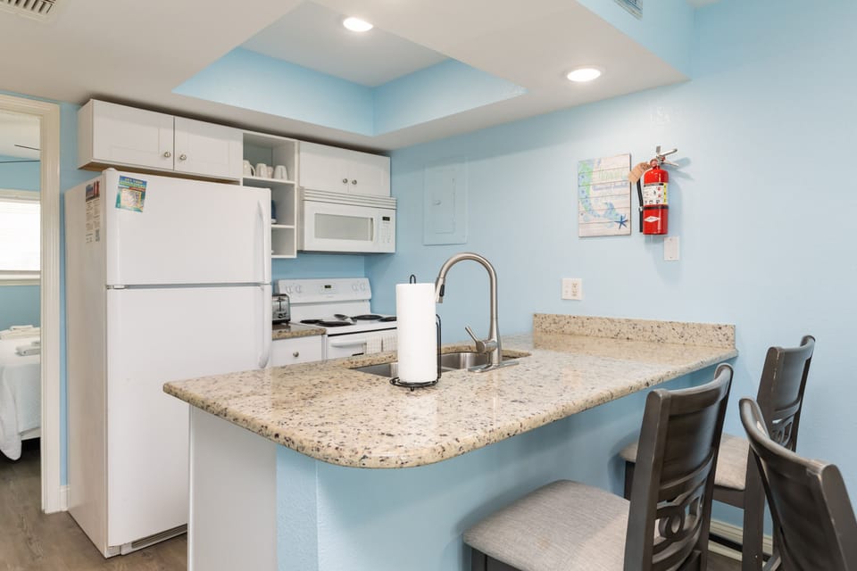 Your fully equipped kitchen awaits with granite countertops, modern appliances, and a breakfast bar where you can enjoy morning coffee together.