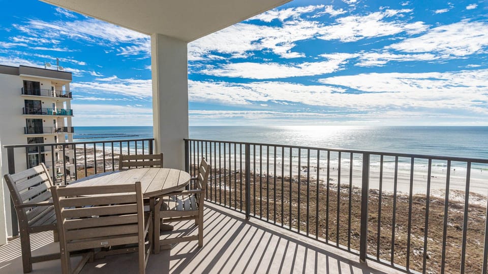Balcony seating offers a serene view of the shimmering gulf and white sand beach, perfect for relaxing moments