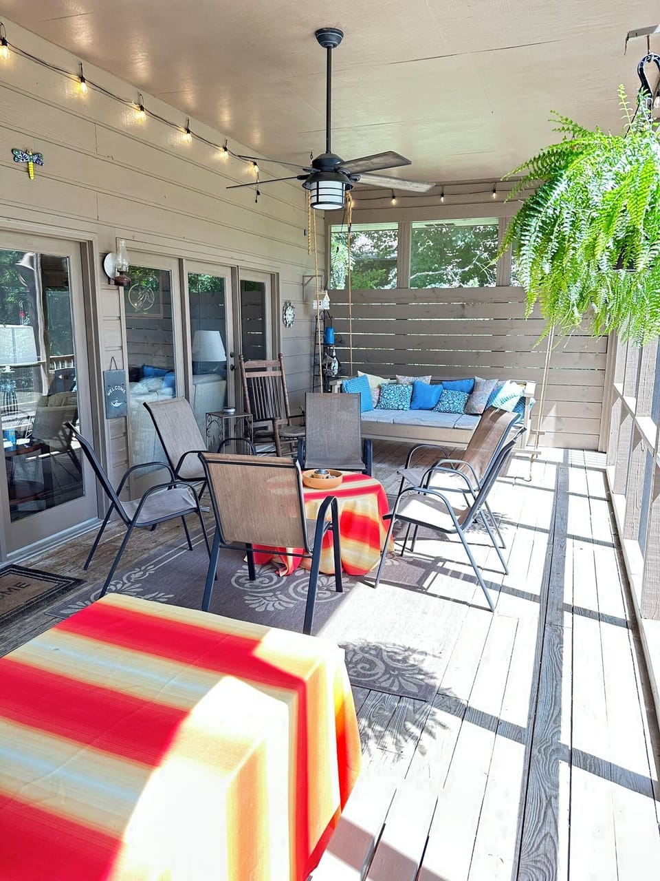 Large screened porch overlooks the lake, with picnic table and swinging day bed