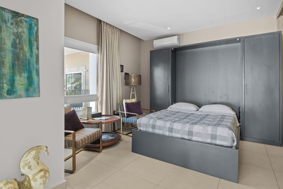 Living Room - features a double-size Murphy bed that folds away effortlessly to maximize space, sliding doors for added privacy when used as a second bedroom, and a cozy private balcony with charming street views.