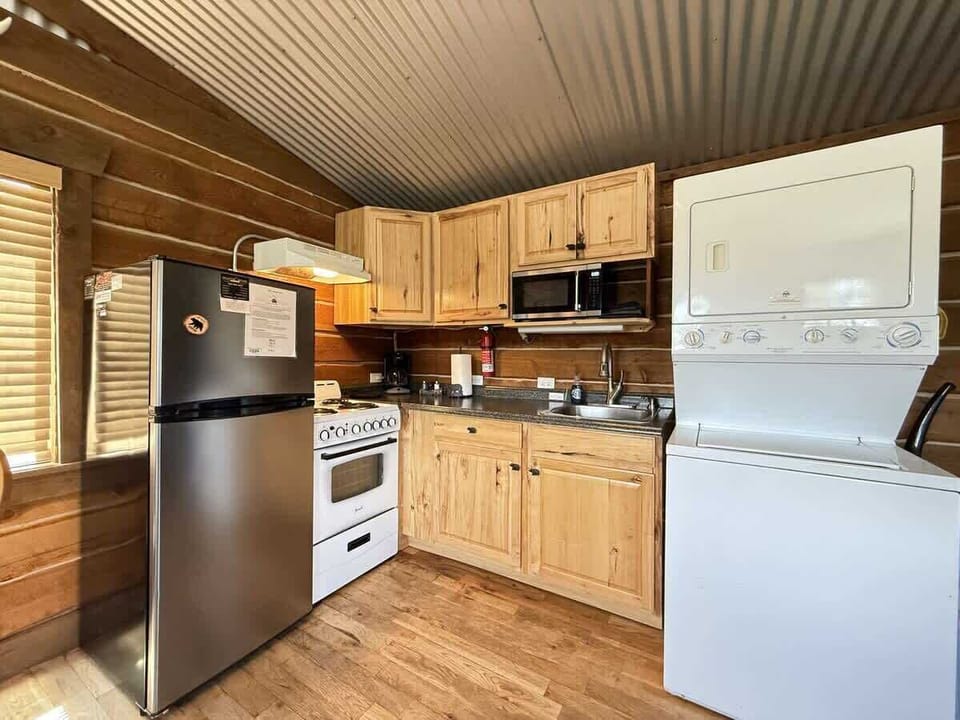 Kitchen area that is equipped with appliances, pots and pans, dishes, utensils, and basic cooking essentials.