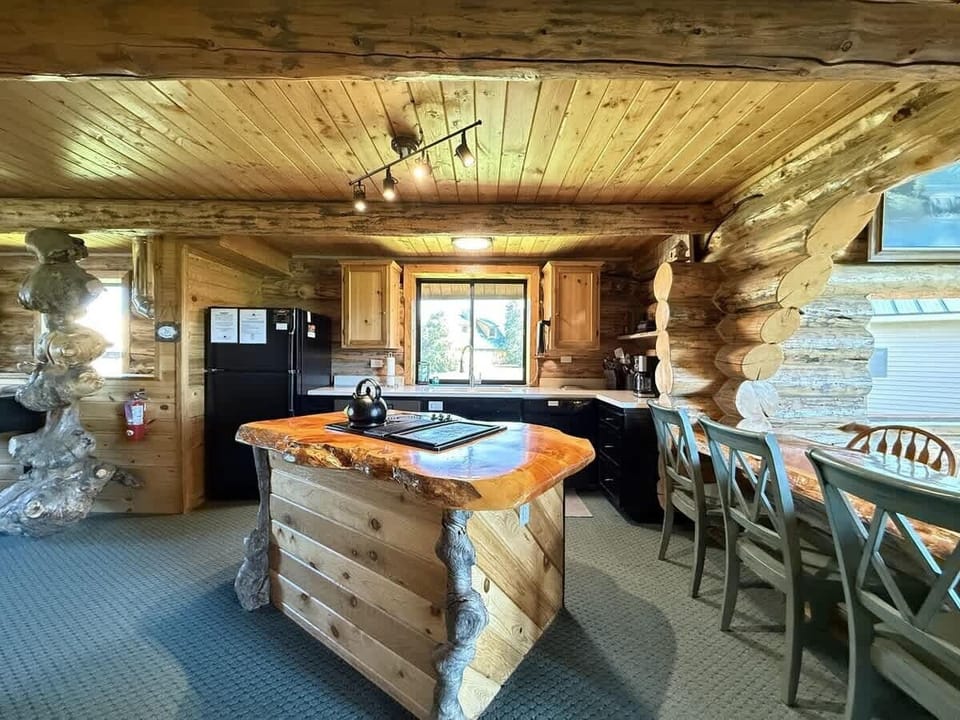 The kitchen in the cabin is a perfect blend of rustic charm and modern convenience, creating a warm and inviting space for cooking, gathering, and enjoying meals.