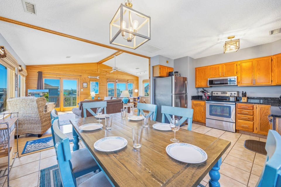 Gather around the spacious dining table with your group, where bright windows frame stunning views and the fully-equipped kitchen invites you to create memorable meals together.