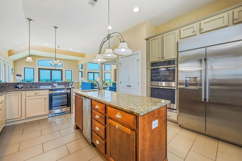 Prepare meals in your spacious kitchen with ocean views streaming through tall windows, stainless steel appliances at your fingertips, and a welcoming island for gathering with loved ones.