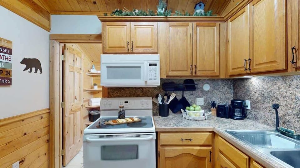 Kitchen equipped with a stove, oven, and microwave along with basic kitchen essentials.
