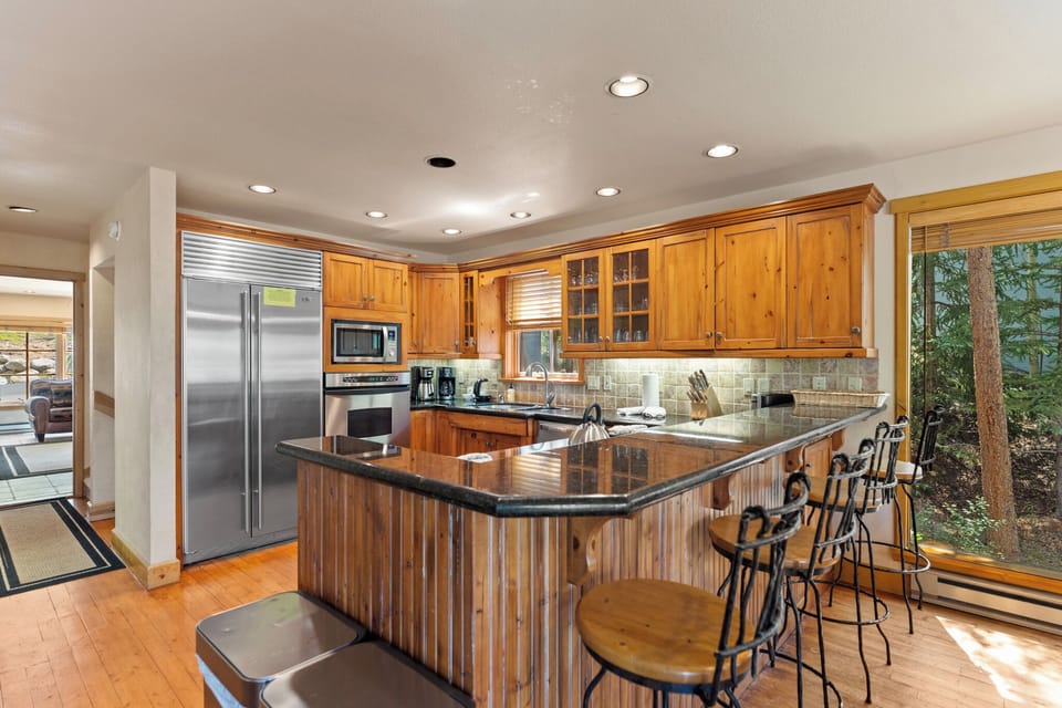 The full kitchen includes all stainless steel appliances, and a breakfast bar seating up to 4.