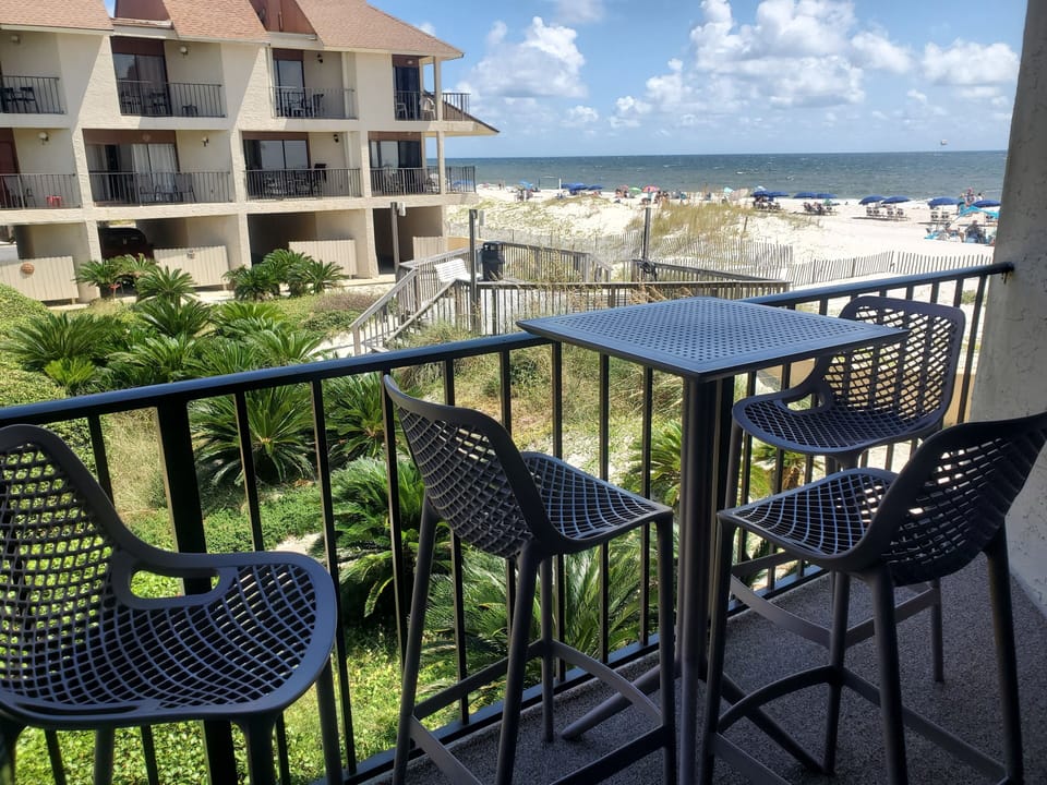 Living room's private balcony has table, 4 bar stools & great beach view.