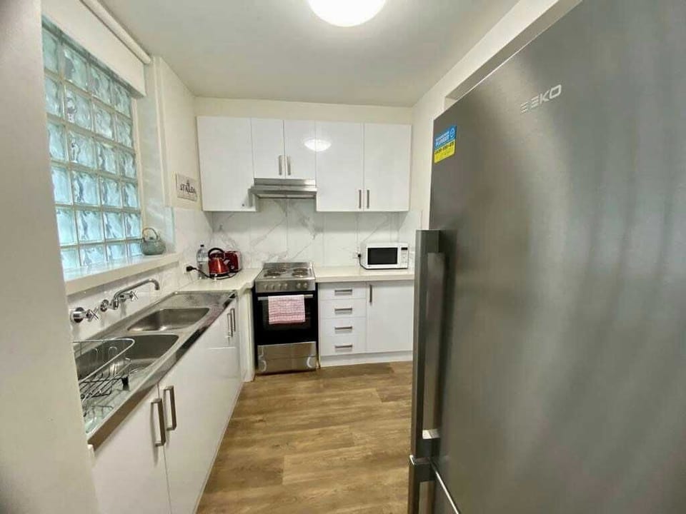 Separate kitchen has plenty of bench space and large family size refrigerator 