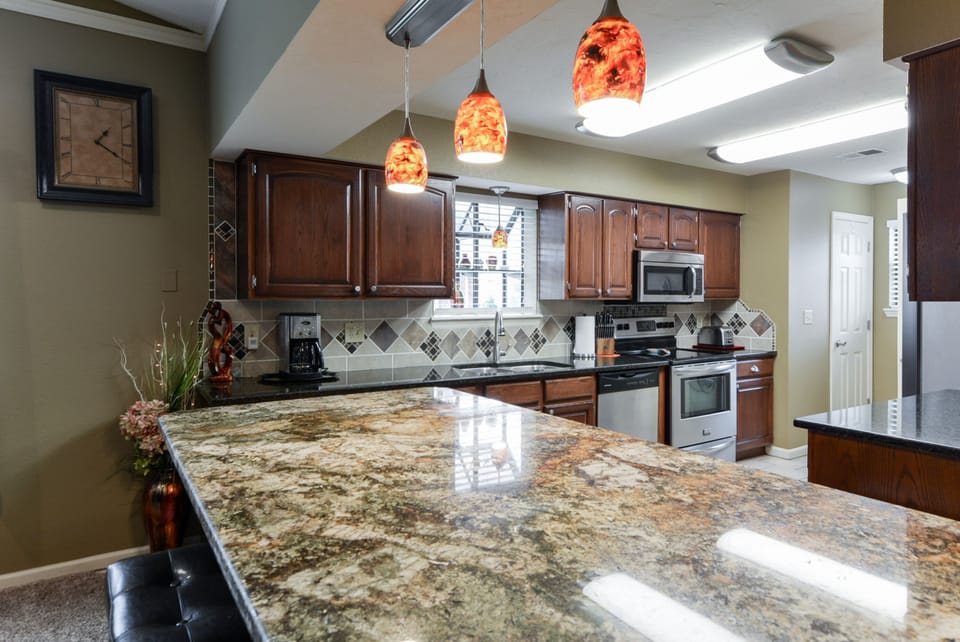 Well stocked kitchen, granite counters, stainless appliances, tile floor