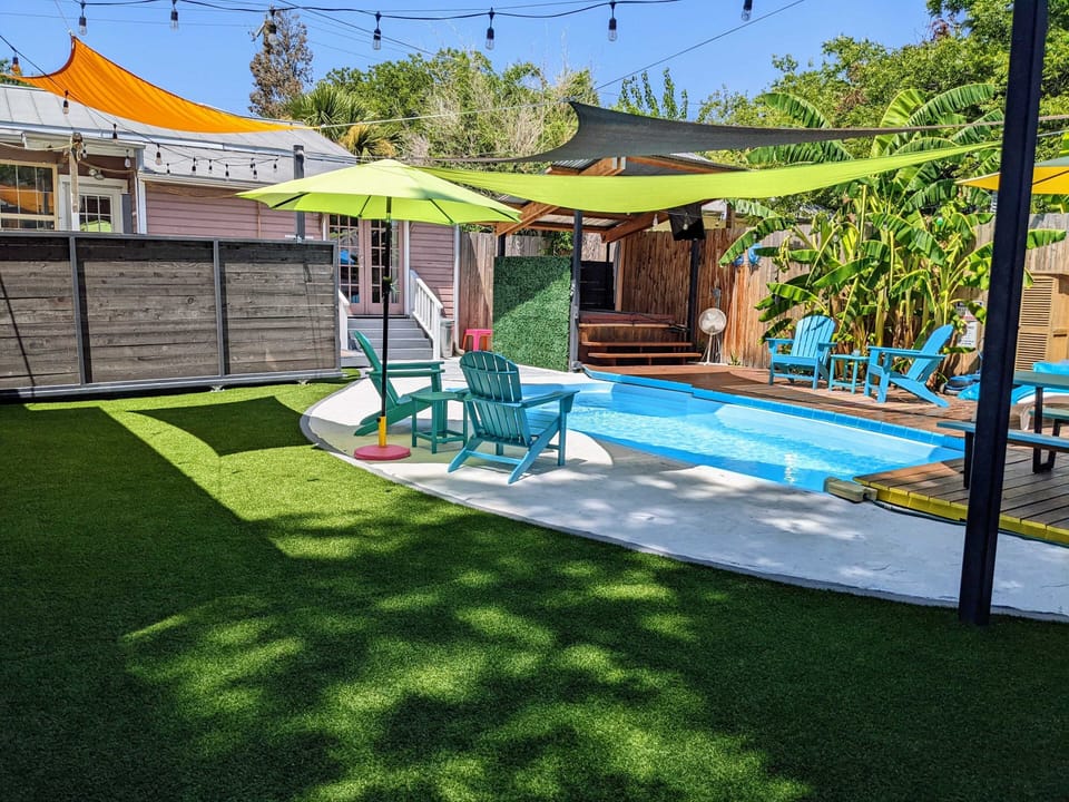Backyard oasis with cocktail pool, deck, seating for 6, shade sails, astroturf.