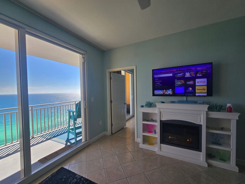 Cozy direct beachfront living room with electric fireplace for colder evenings!