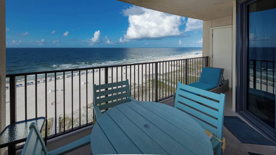 Patio table and chairs on the balcony offer a perfect spot to enjoy the serene beachfront view and gentle ocean breeze