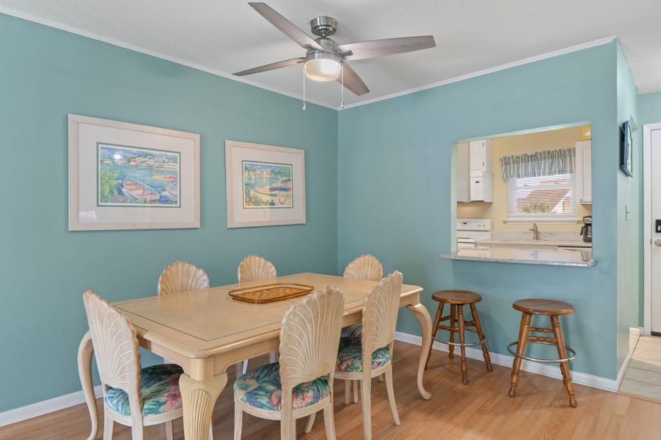 Your bright dining space features tropical-themed artwork and opens to a fully equipped kitchen through a convenient pass-through window.