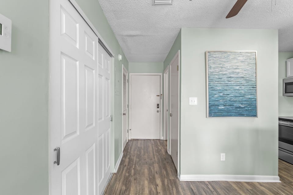 Step into your bright, airy hallway featuring soothing coastal colors and beautiful ocean artwork that welcomes you home.