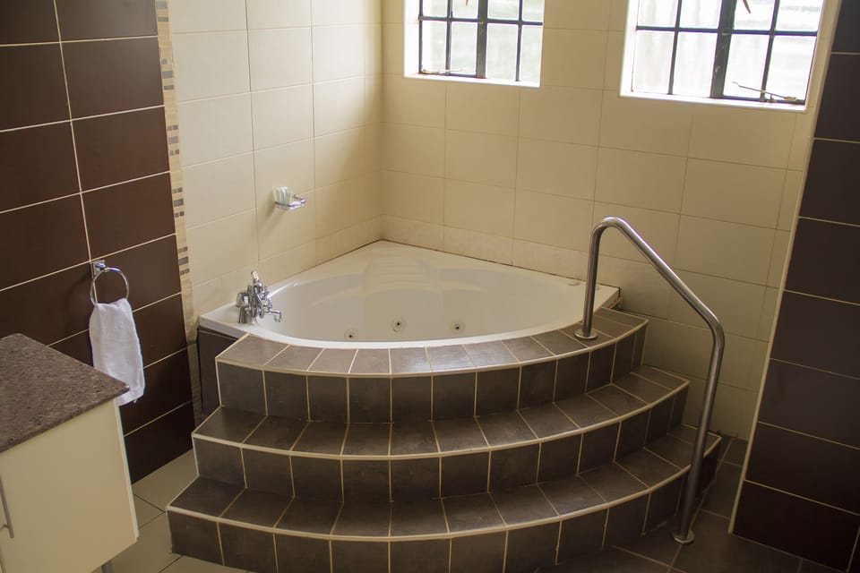 Deluxe king room with balcony and Jacuzzi | Bathroom | Shower, free toiletries, towels, soap