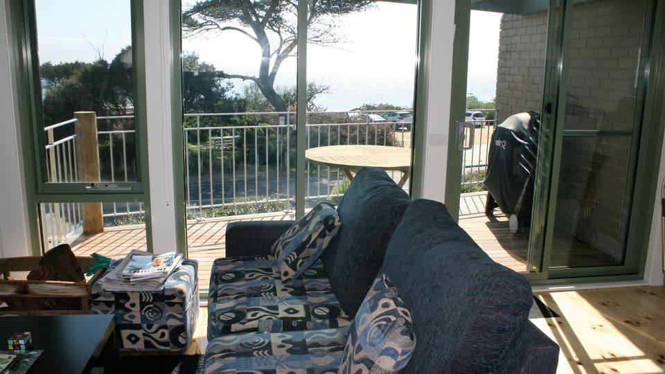 Upstairs lounge and view of balcony. Weber BBQ on balcony. Outdoor table + chrs.