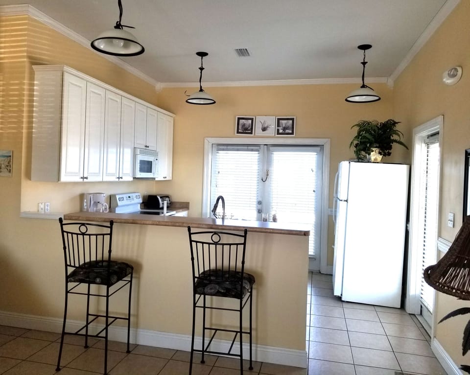 Full kitchen with breakfast bar, open to living area.