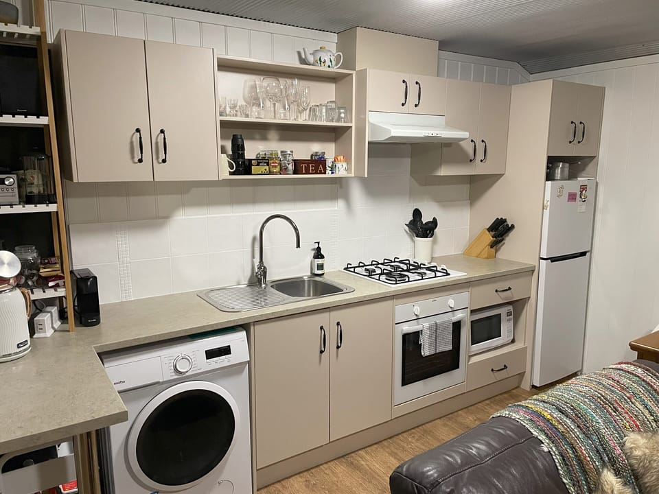 Self contained kitchen with electric oven, gas hotplates and microwave.
