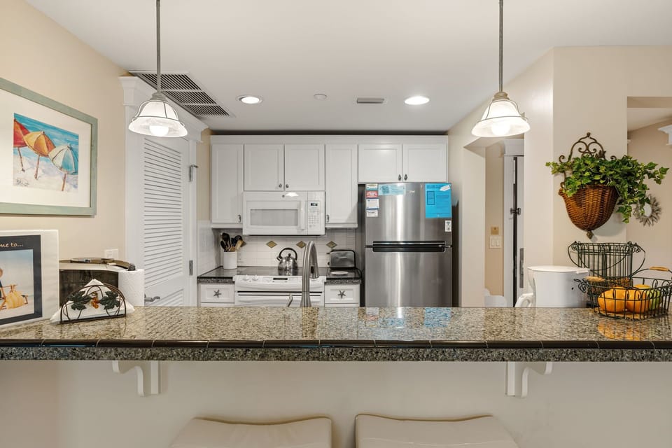 Kitchen view from dining area with 2 counter height bar stools