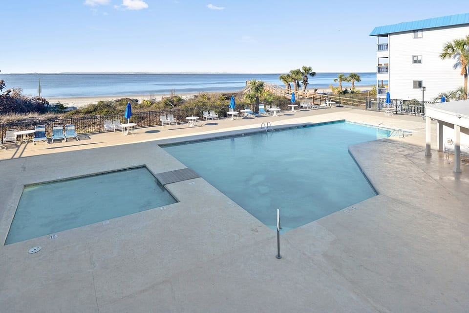 Pool area with chairs and umbrellas.