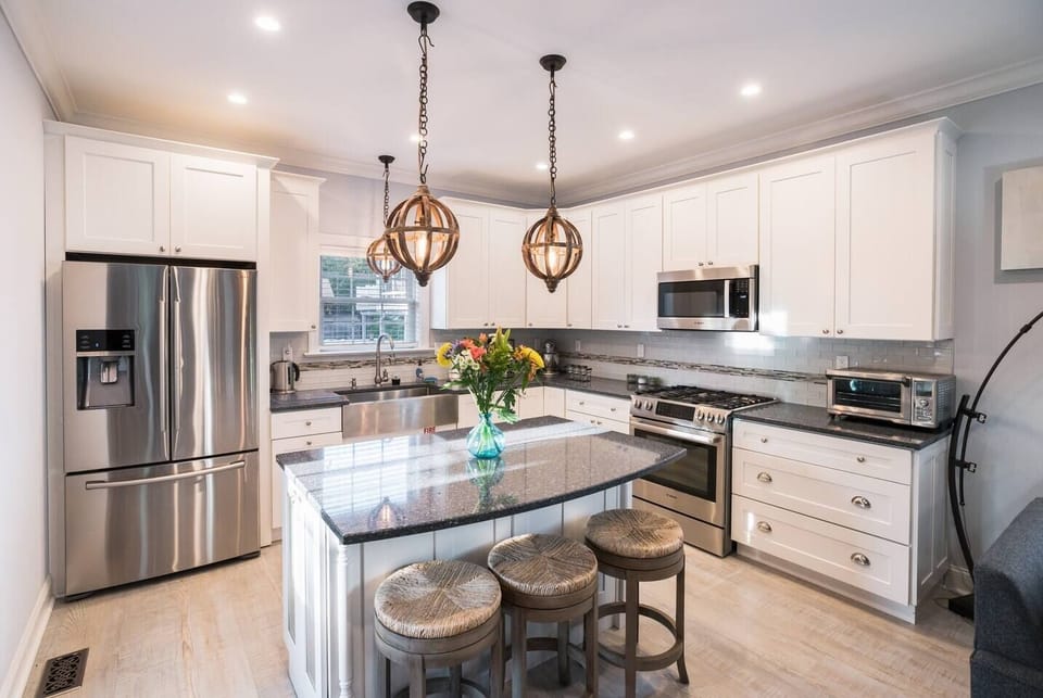 Fully stocked kitchen with gas range, garbage disposal, toaster oven, blender, water kettle, drip coffee maker and KitchenAid mixer.