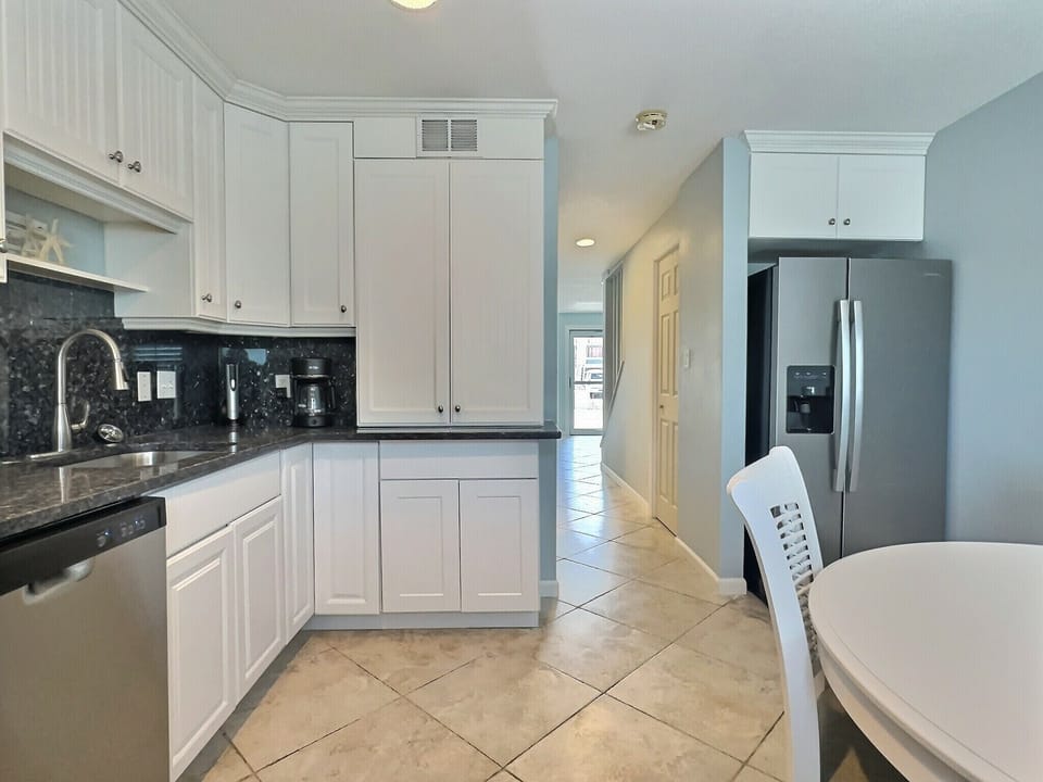 Full kitchen view with stainless refrigerator, dishwasher, and ample cabinetry