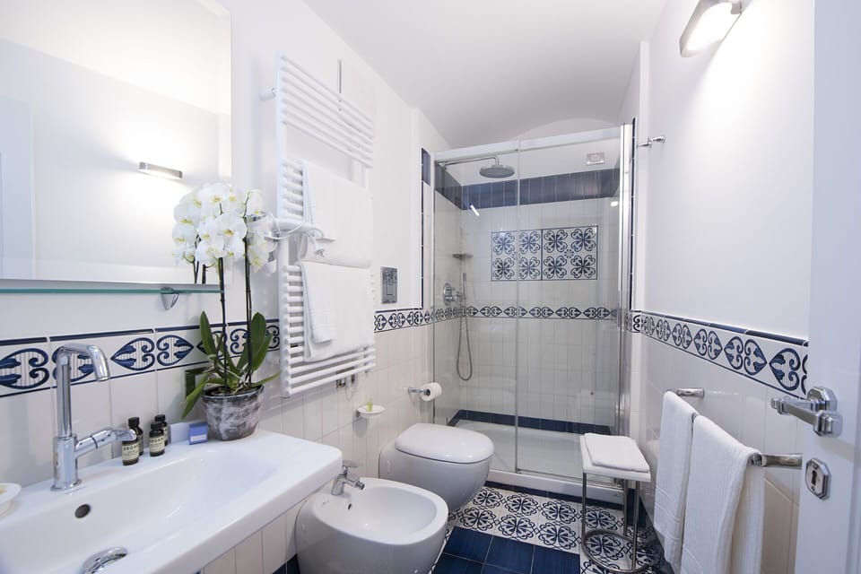 Classic Quadruple Room | Bathroom | Rainfall showerhead, free toiletries, hair dryer, slippers