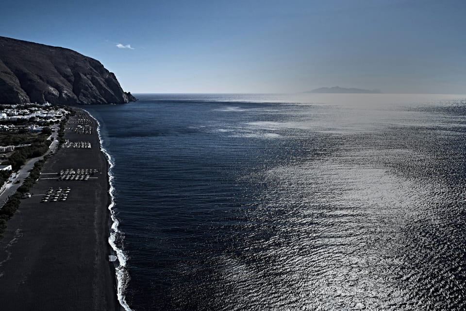 On the beach, black sand, sun loungers, beach towels