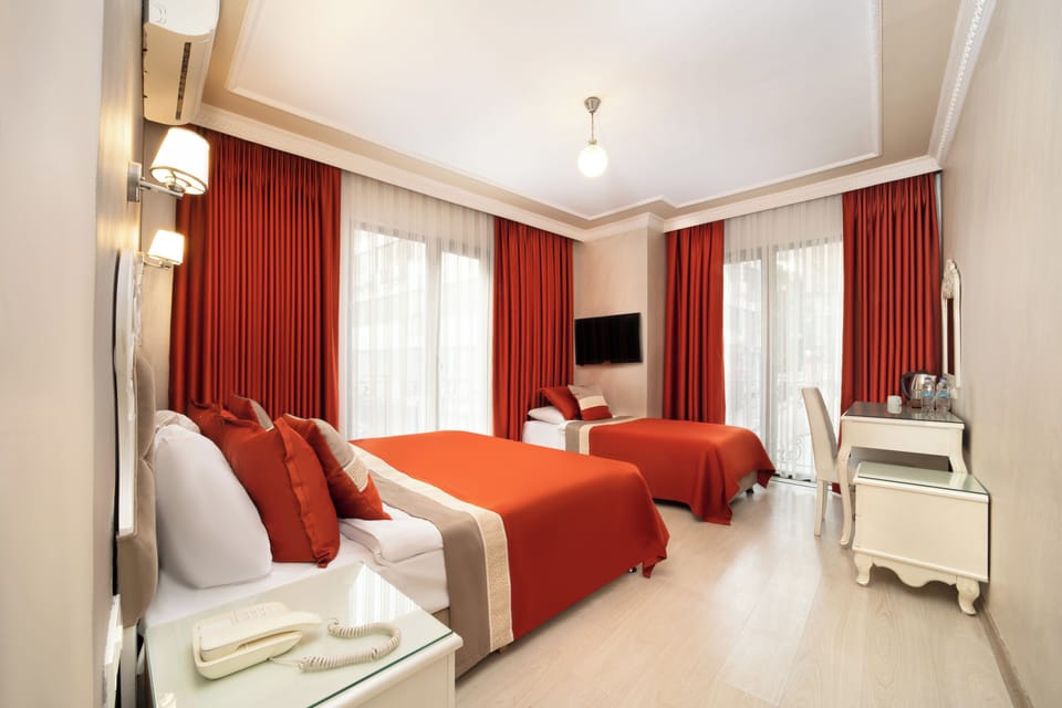 Deluxe Triple Room | Minibar, in-room safe, desk, laptop workspace