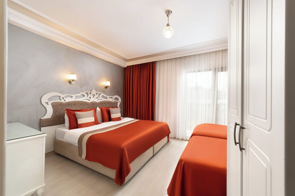Deluxe Quadruple Room | Minibar, in-room safe, desk, laptop workspace