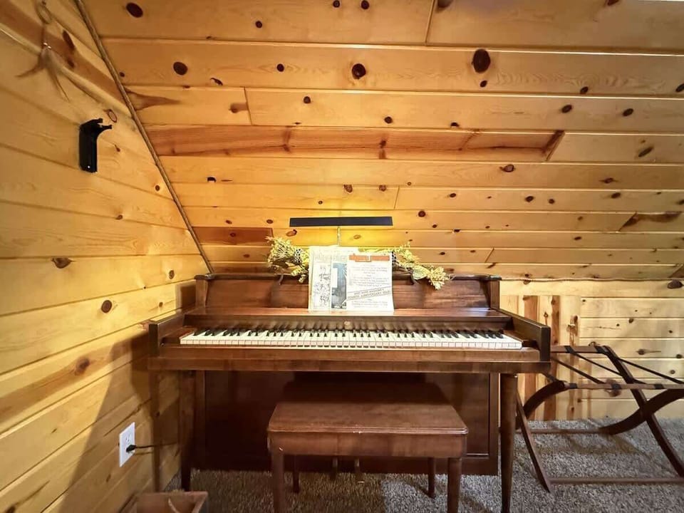 Upstairs loft corner with piano and seating.