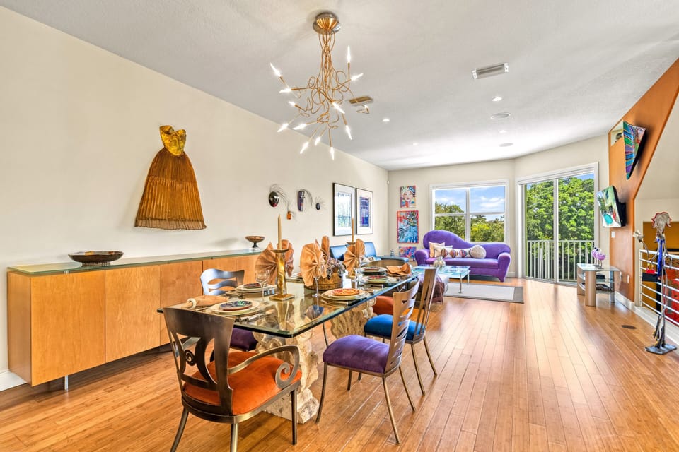 The dining table flows seamlessly into the living space, offering an open, airy layout perfect for connection and conversation.