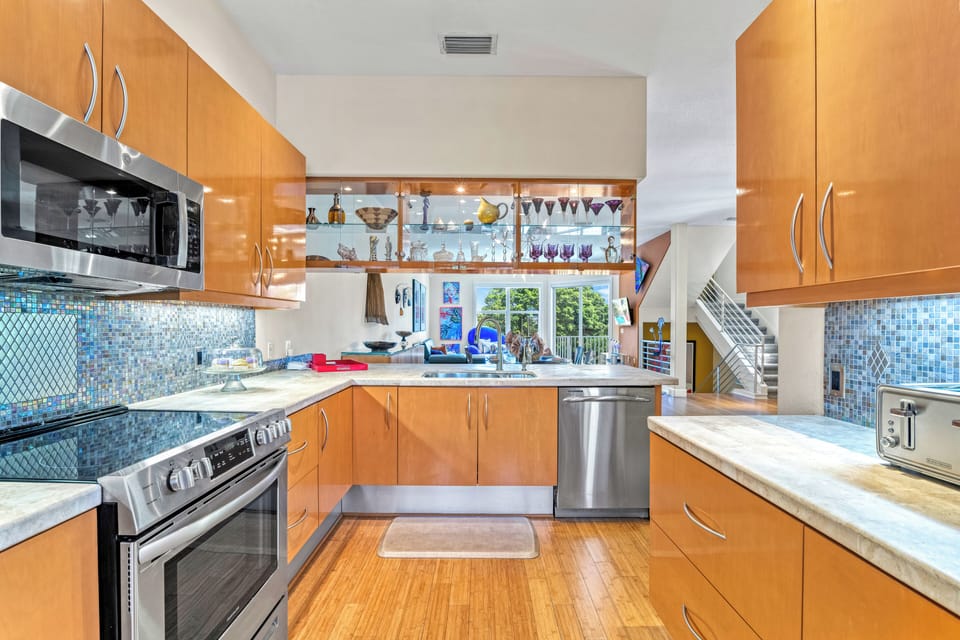 A wide view showcases modern appliances, generous counter space, and everything you need to cook and gather with ease.