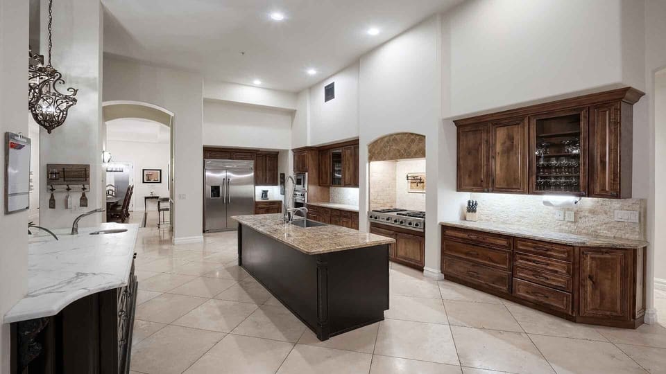 Grand luxury kitchen w/ endless counter space, large fridge, & chefs' gas stove
