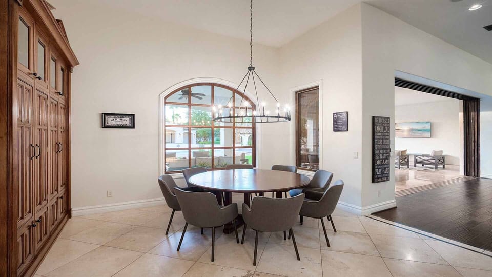 Round dining table seating 8 people next to the kitchen w/ backyard views