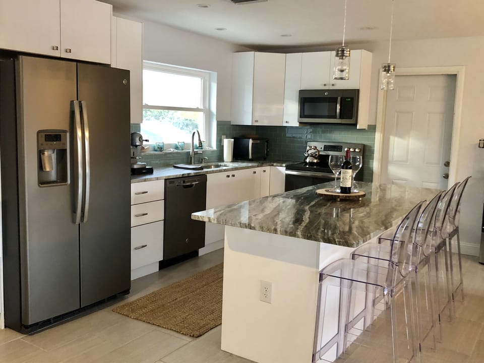 Updated kitchen with new appliances,  eat-in bar with four counter-height stools