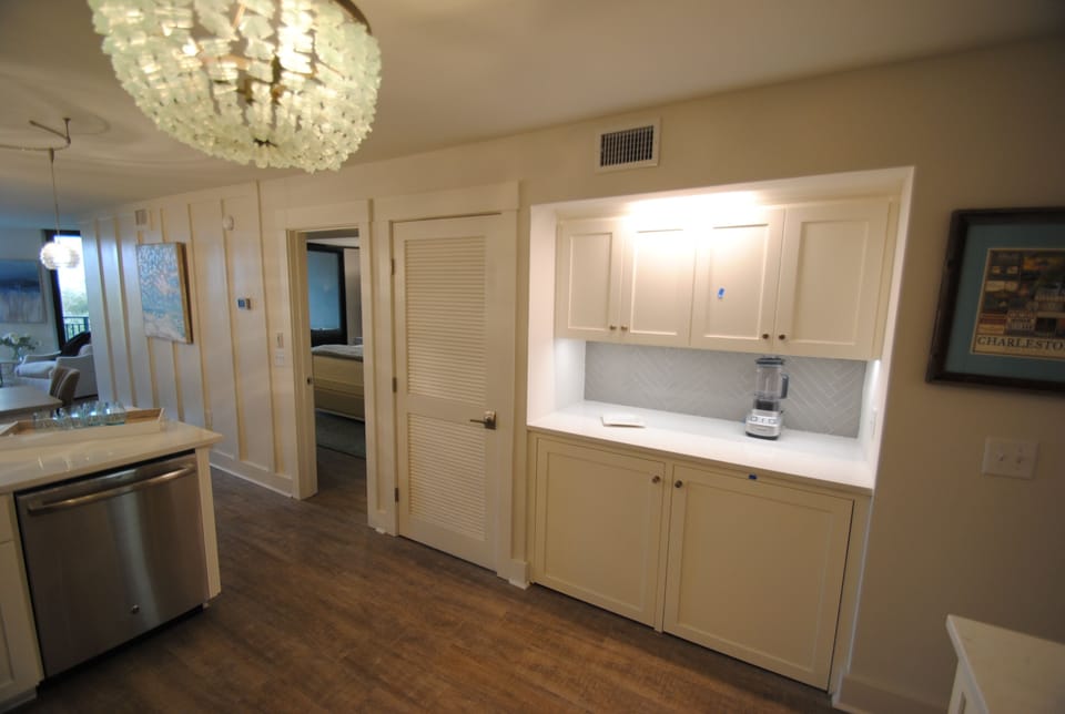 Nifty bar/laundry area with washer dryer hidden below-slide away cabinet doors.
