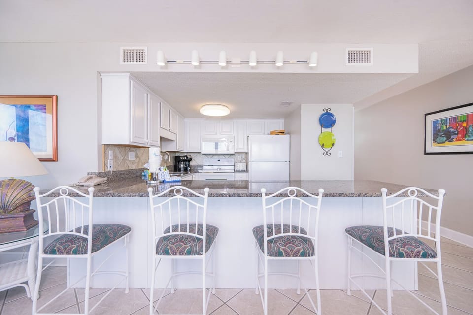 Enjoy morning coffee at the bar while savoring the bright kitchen's inviting decor and convenient layout
