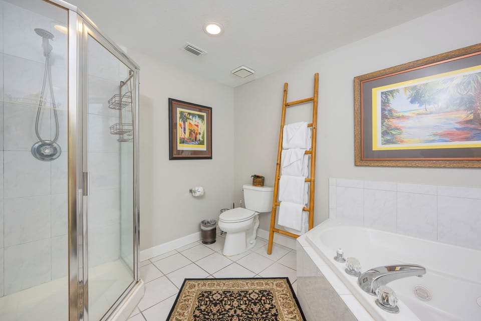 A refreshing shower and relaxing tub await in the master bath with towels ready on the bamboo ladder