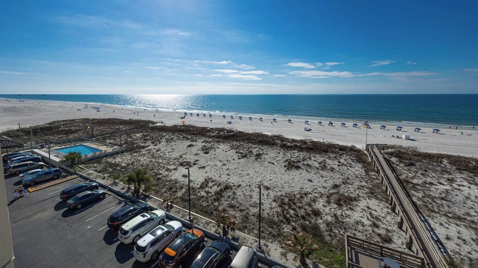 Enjoy a breathtaking beachfront view with vibrant blue waters and white sand, perfect for a relaxing getaway