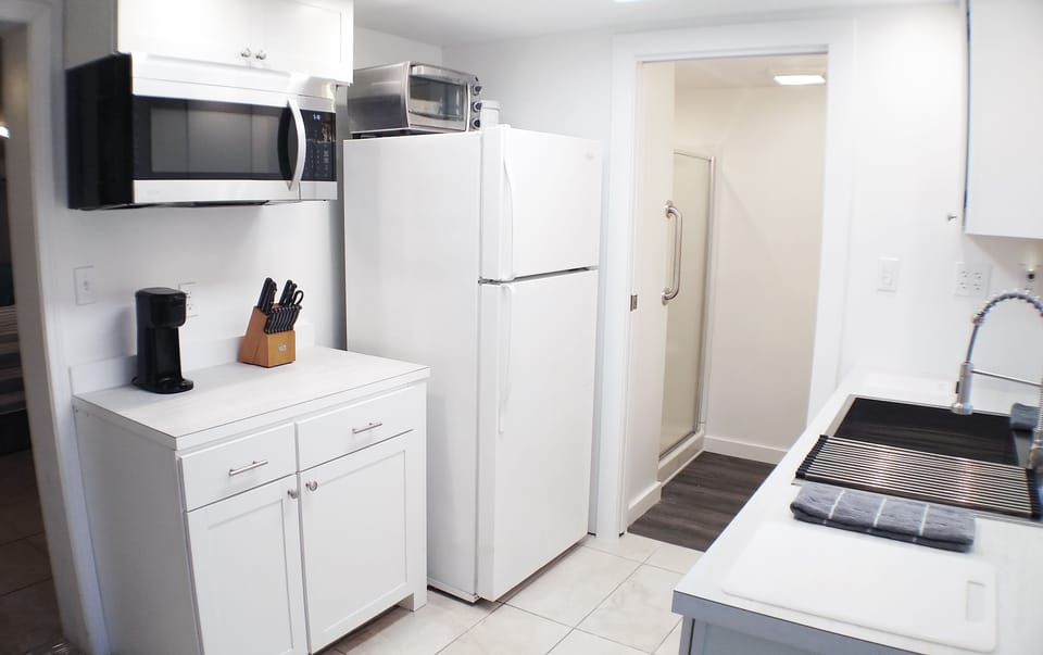 Kitchen with a full size refrigerator and a full size microwave. 
