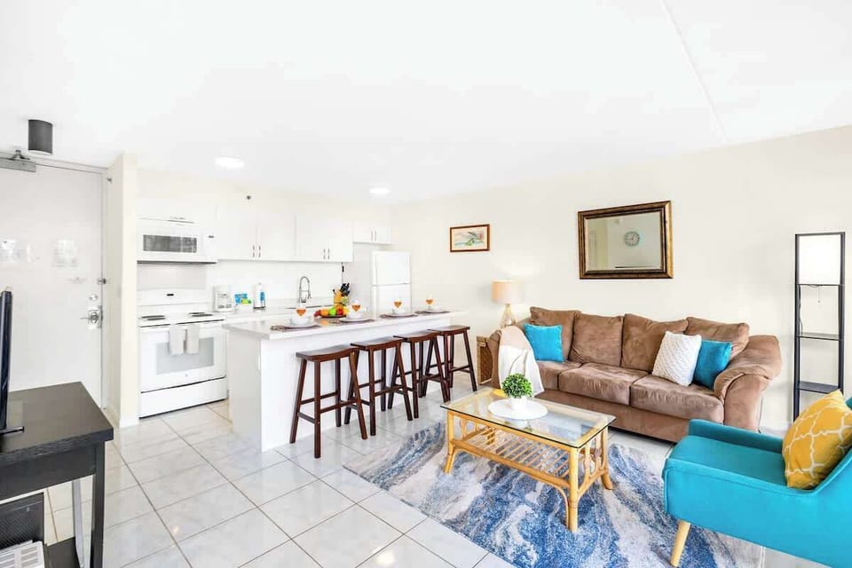 The living room features a queen-size sleeper sofa, coffee table, chair, and countertop with 4 bar stools!