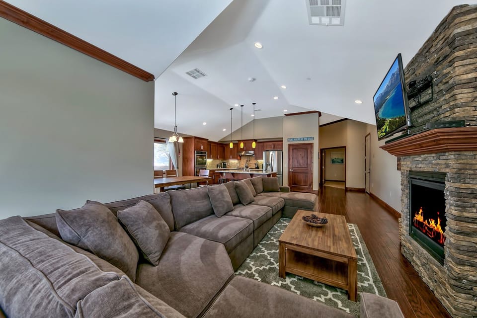 Sink into plush sectional seating by your crackling stone fireplace, while the open kitchen invites culinary adventures in this elegant retreat.