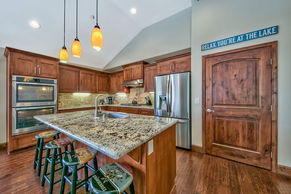 Cook together in your spacious kitchen featuring granite counters, stainless appliances, and warm wood cabinetry perfect for memorable vacation meals.