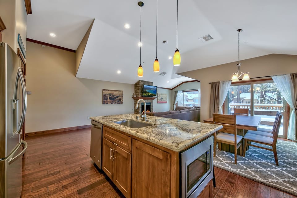 Your spacious kitchen island anchors this open-concept haven, where granite countertops and warm wood blend seamlessly with your dining and living spaces.