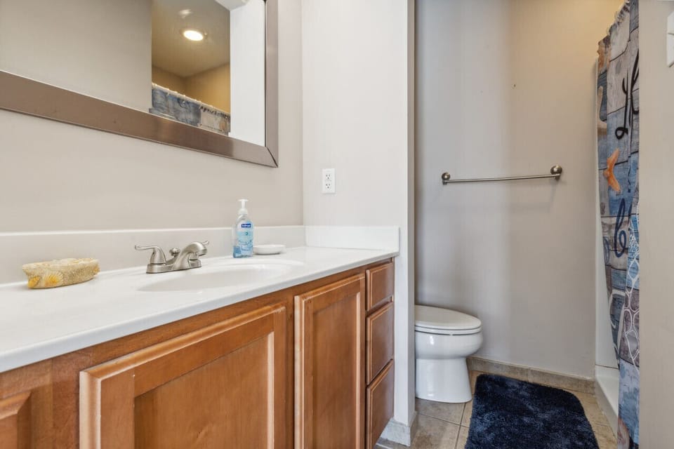 The primary bathroom has a walk-in style shower and plenty of counter space for two.