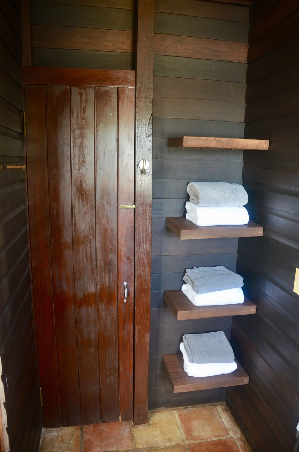 neat floating shelves in bath next to door to bedroom
