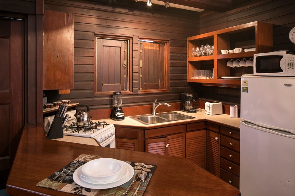 kitchen with tiled and wooden countertops.  windows open to ocean view