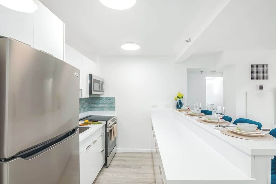 Prepare your favorite meals in the sleek, fully-equipped kitchen, featuring modern appliances and a convenient breakfast bar perfect for casual dining.