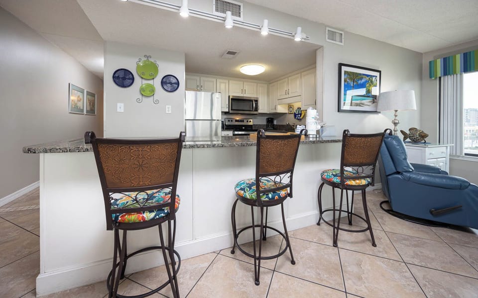 This inviting kitchen features stylish bar seating, stainless appliances, and a vibrant view of the surrounding area